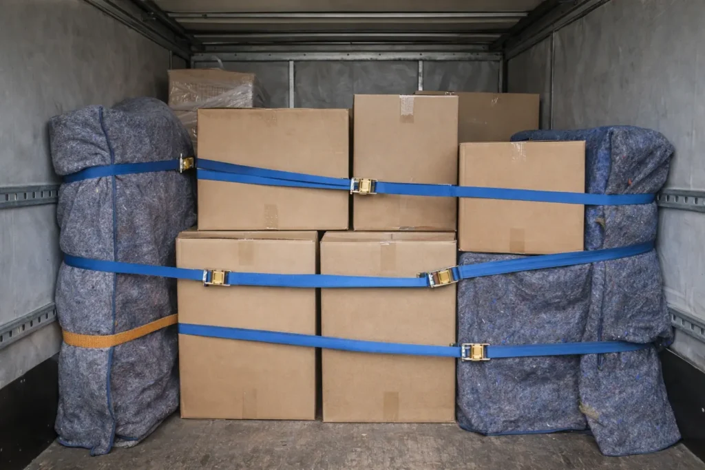 Фиксация коробок ремнями-стяжками и защита мебельными одеялами для перевозки хрупких вещей